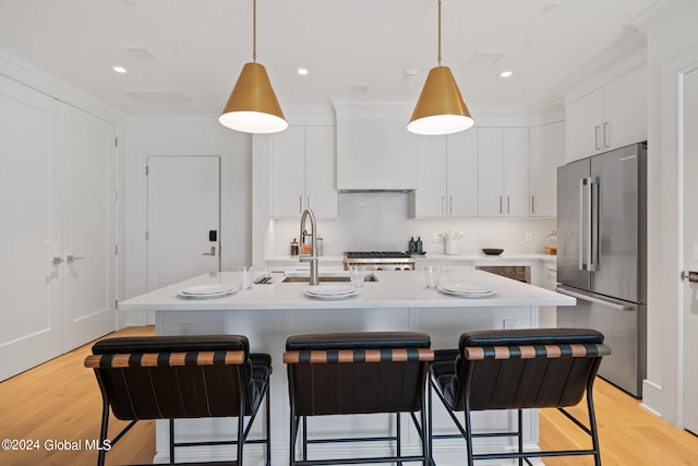 kitchen featuring a breakfast bar, light countertops, light wood-style floors, and high end fridge