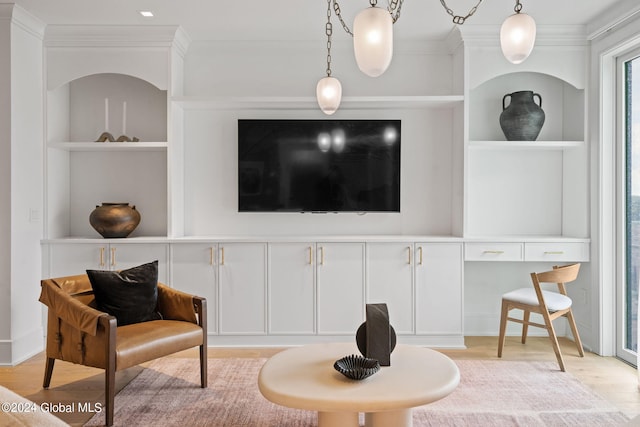 sitting room with built in features, ornamental molding, and wood finished floors