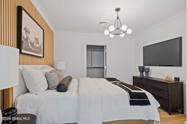 bedroom featuring visible vents, a notable chandelier, wood finished floors, a closet, and crown molding