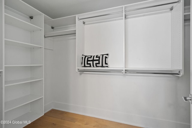 walk in closet with wood finished floors