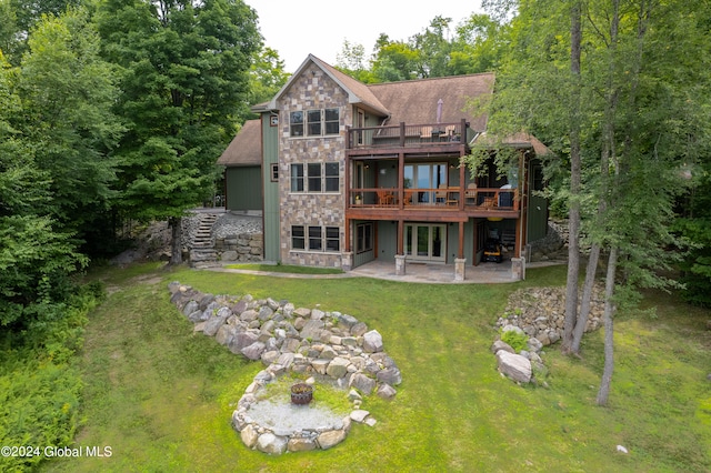 rear view of property with a patio, a wooden deck, and a lawn