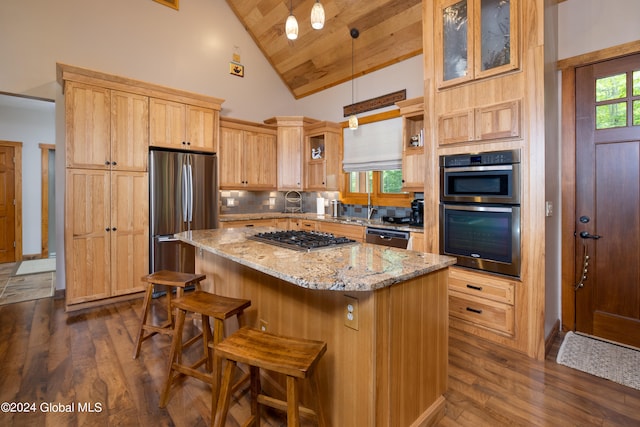 kitchen with a kitchen island, appliances with stainless steel finishes, dark hardwood / wood-style flooring, and decorative light fixtures