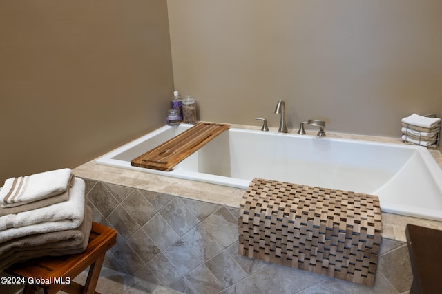 interior space featuring a relaxing tiled tub and tile patterned floors