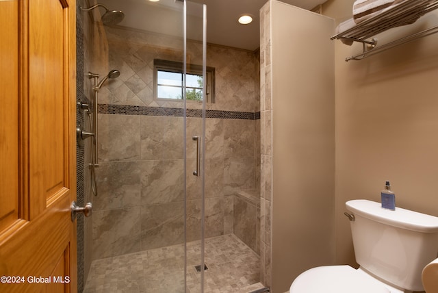 bathroom with a shower with shower door and toilet