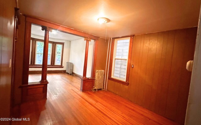 hall featuring wooden walls, hardwood / wood-style floors, and radiator