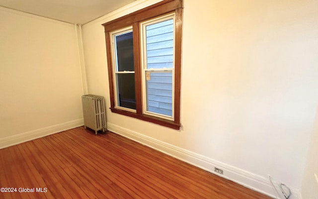 spare room with hardwood / wood-style flooring and radiator