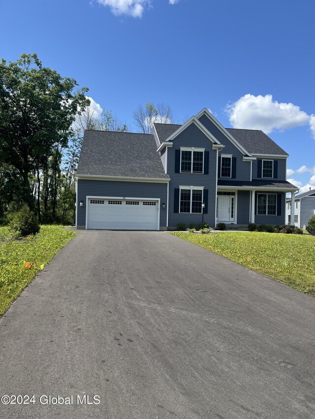 view of front property featuring a garage and a front lawn