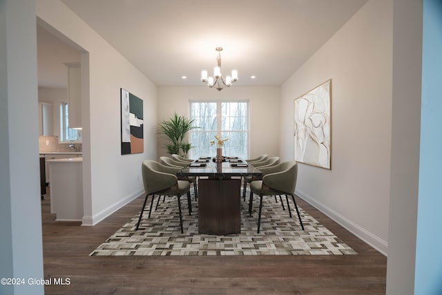 dining area with an inviting chandelier, baseboards, and wood finished floors