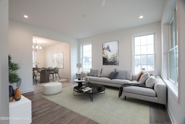 living room with dark hardwood / wood-style flooring and an inviting chandelier