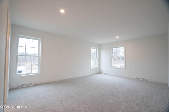 empty room featuring recessed lighting, carpet flooring, visible vents, and baseboards