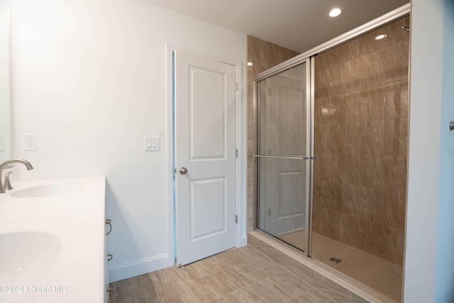 bathroom with a shower with shower door, tile patterned floors, and dual bowl vanity