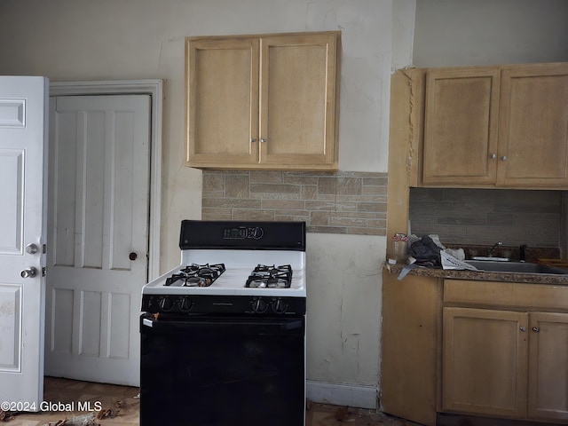 kitchen featuring light brown cabinetry, sink, decorative backsplash, and range with gas stovetop