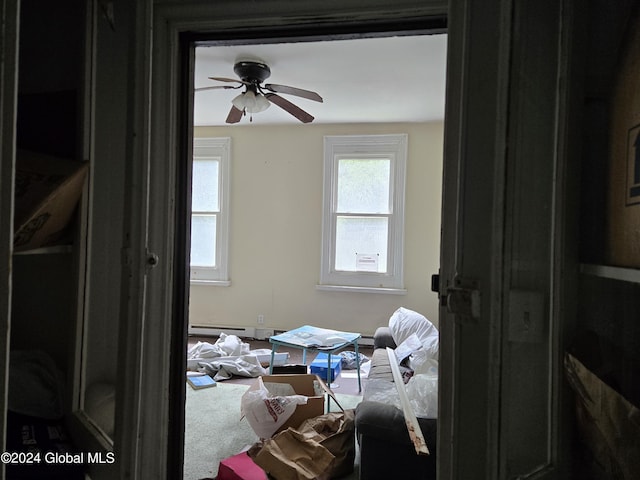 bedroom with baseboard heating, ceiling fan, carpet floors, and multiple windows