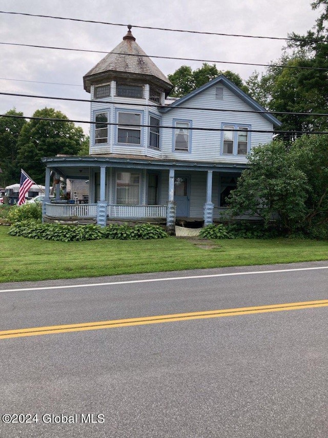 victorian home featuring a front lawn and a porch