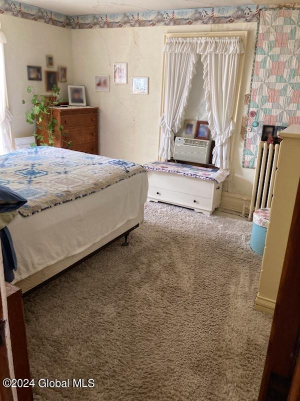 carpeted bedroom featuring radiator heating unit