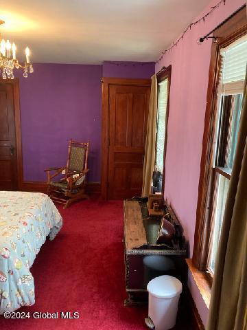 bedroom featuring carpet floors and a chandelier