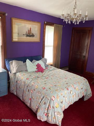 bedroom with carpet flooring and an inviting chandelier