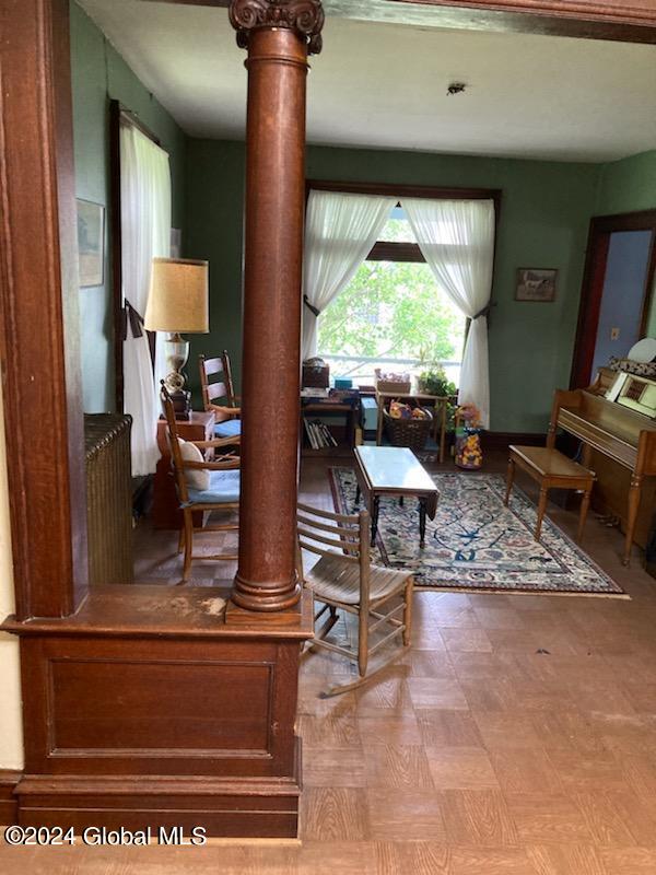 living room with parquet flooring and ornate columns