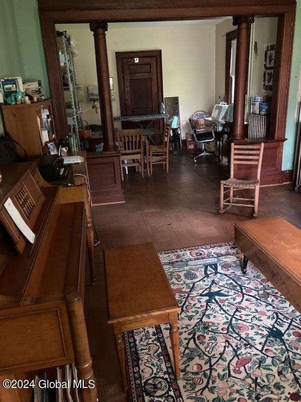 living room with dark tile patterned floors and ornate columns