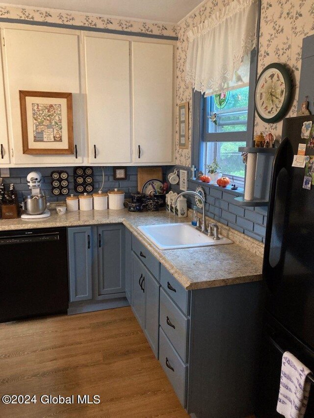 kitchen featuring black appliances, sink, white cabinetry, and backsplash