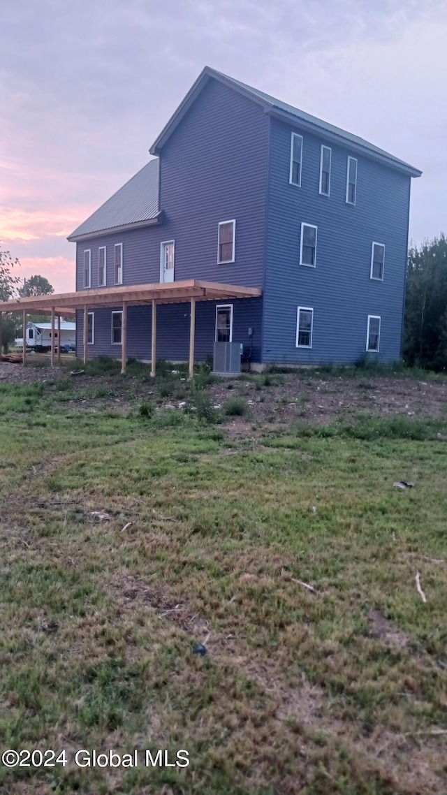 back house at dusk featuring central AC unit