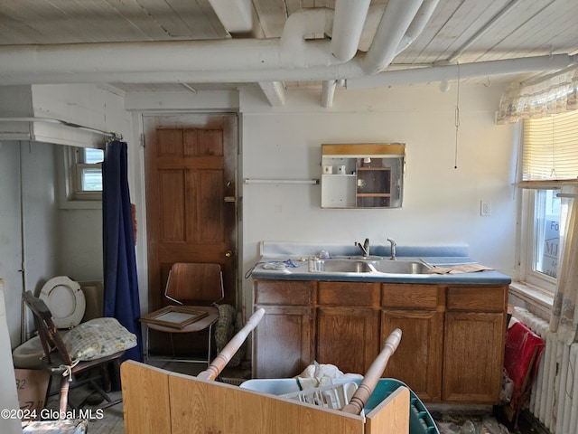 kitchen featuring beam ceiling, sink, and a healthy amount of sunlight