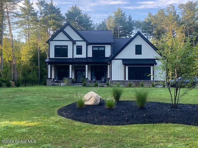 view of front of property featuring covered porch and a front lawn