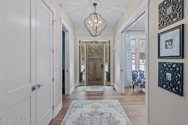 entryway featuring hardwood / wood-style floors and a chandelier