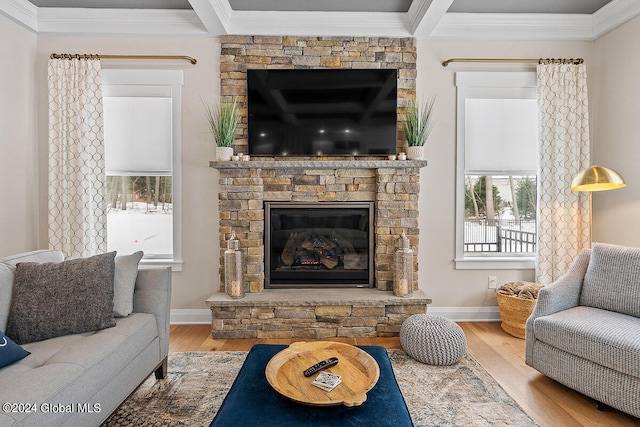 living room featuring crown molding, a fireplace, beamed ceiling, and hardwood / wood-style flooring