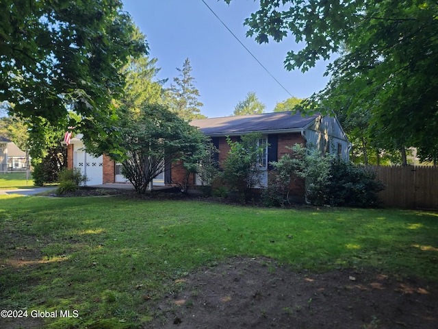 view of property hidden behind natural elements featuring a front yard