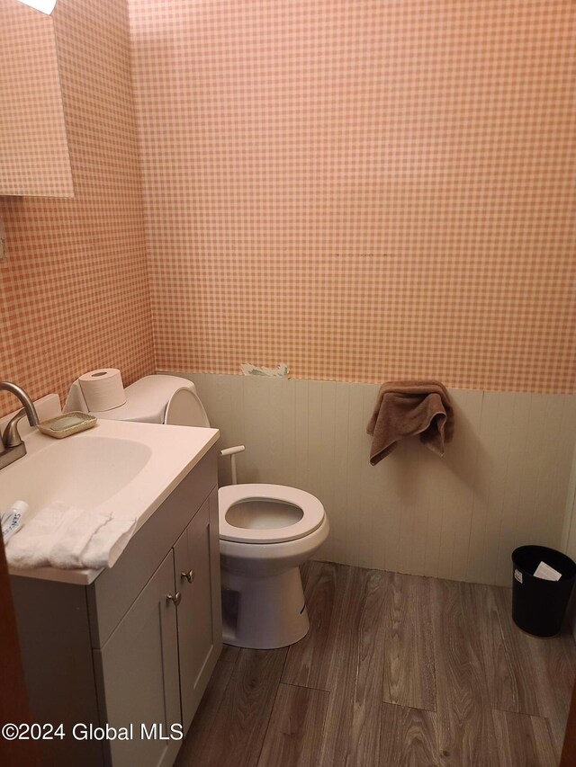 bathroom with hardwood / wood-style floors, toilet, and vanity