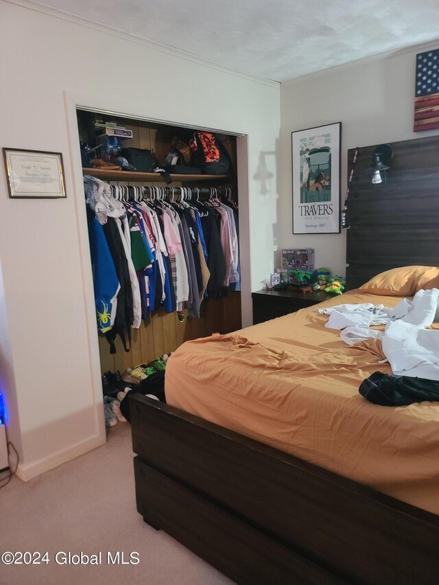 carpeted bedroom featuring a textured ceiling and a closet