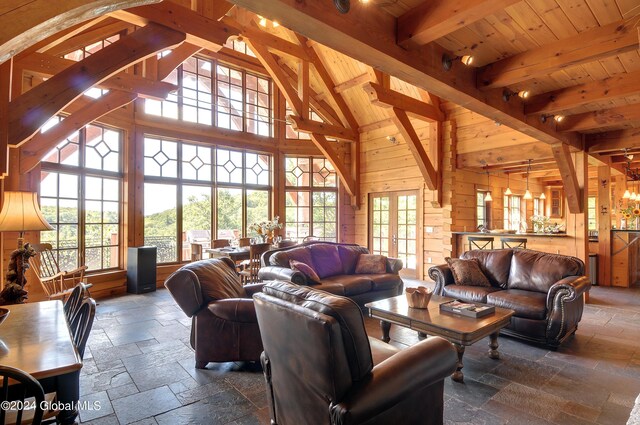 living room featuring high vaulted ceiling, beam ceiling, wooden ceiling, and wooden walls