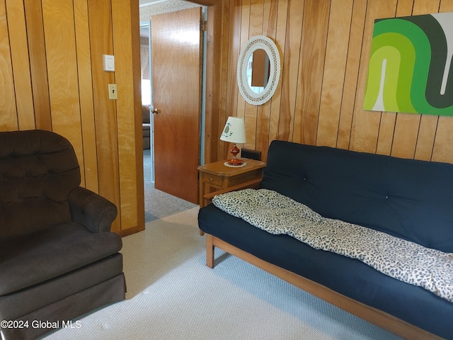 bedroom with carpet flooring and wood walls