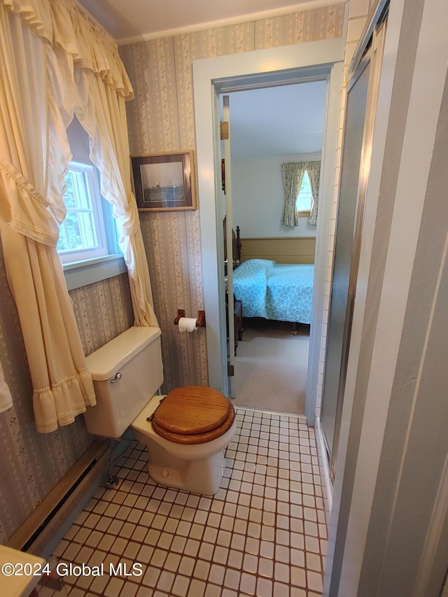 bathroom with an enclosed shower, baseboard heating, and toilet