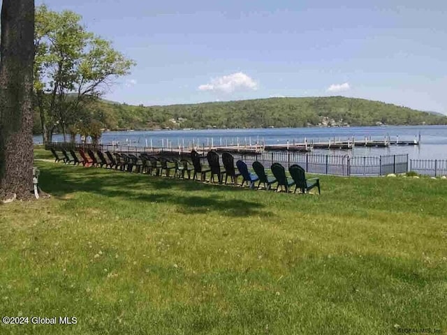 view of property's community with a lawn and a water view