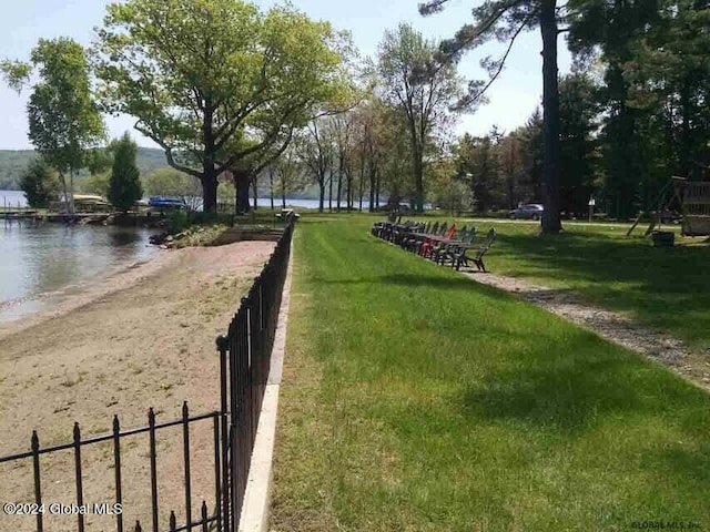 view of home's community with a lawn and a water view