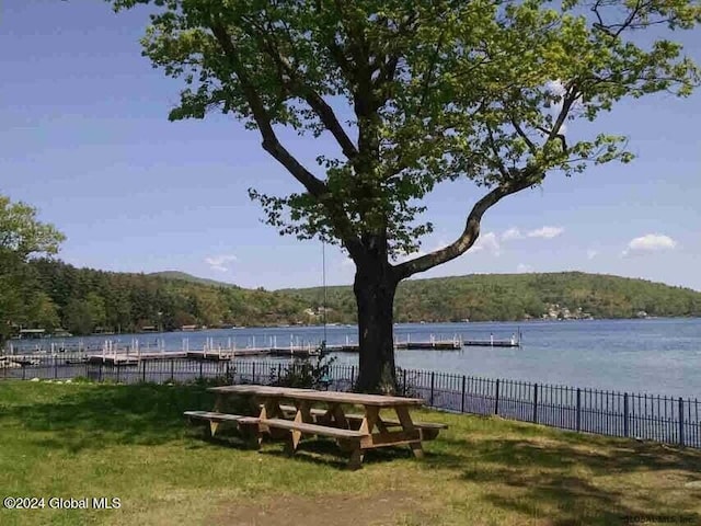 view of home's community with a water view and a yard