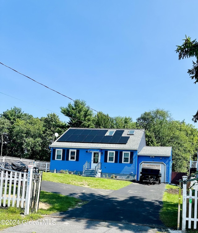 ranch-style home with a front lawn, solar panels, and a garage