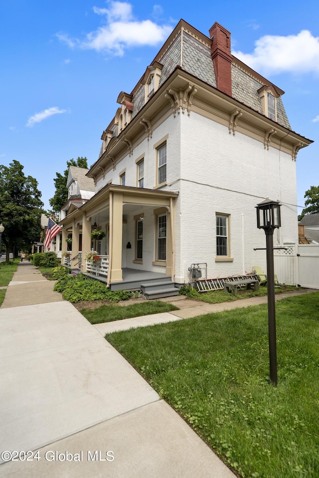 view of property exterior featuring covered porch and a lawn