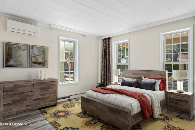 bedroom featuring ornamental molding, hardwood / wood-style floors, a wall unit AC, and baseboard heating