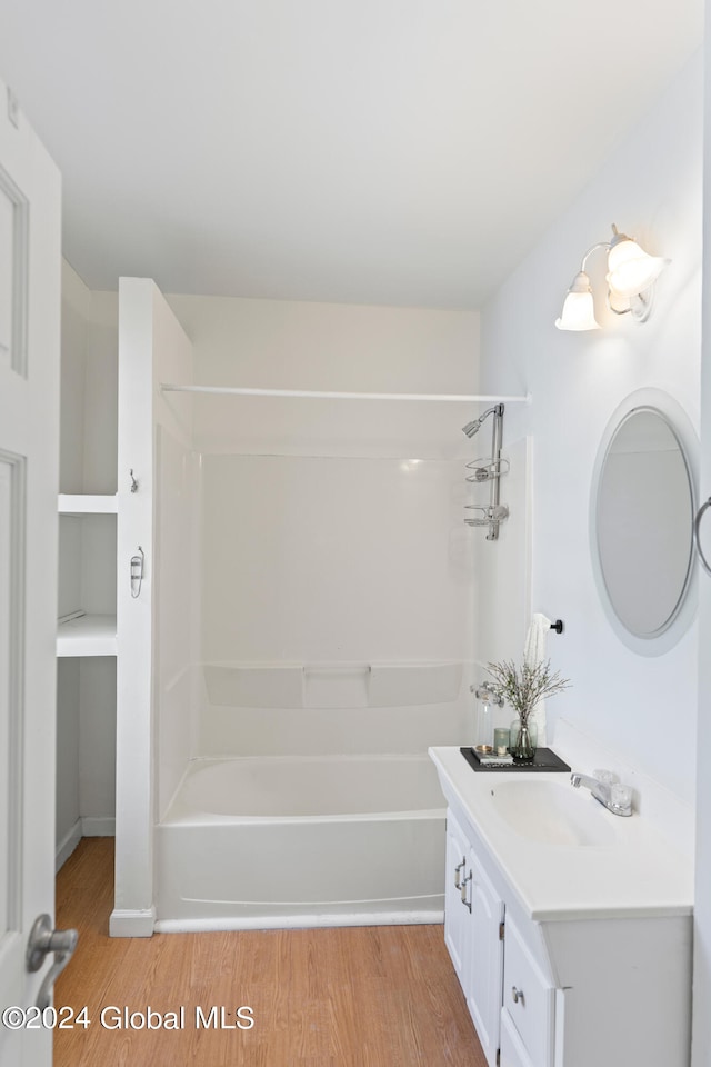 bathroom featuring wood-type flooring, bathtub / shower combination, and vanity