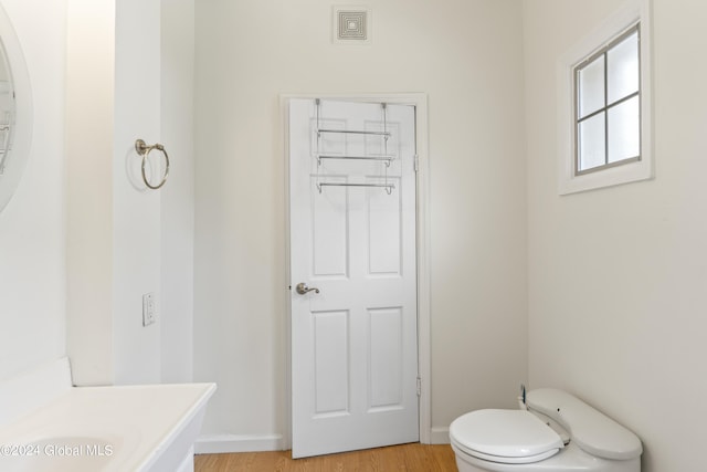 bathroom featuring hardwood / wood-style flooring and toilet