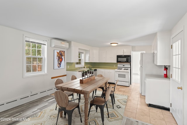 tiled dining space featuring a baseboard heating unit and an AC wall unit