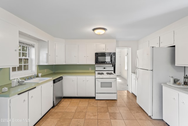 kitchen featuring white cabinetry, sink, light tile patterned floors, and white appliances