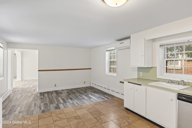 kitchen with sink, dishwasher, baseboard heating, white cabinetry, and a wall mounted air conditioner