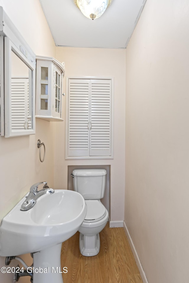 bathroom with hardwood / wood-style floors and toilet