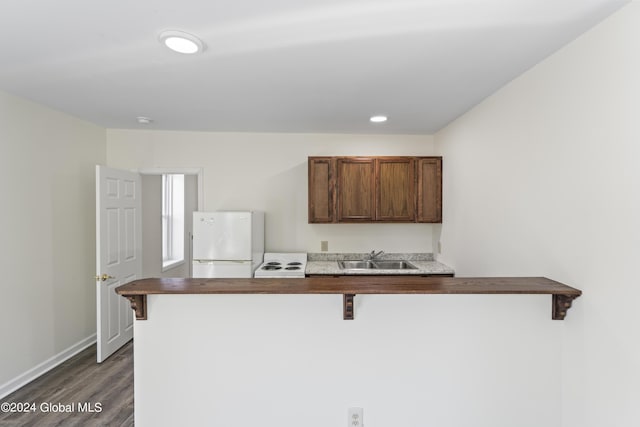 kitchen with a kitchen breakfast bar, kitchen peninsula, sink, and white fridge