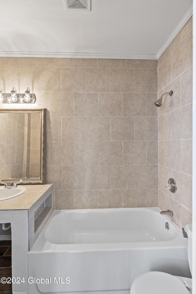 bathroom with tiled shower / bath combo, ornamental molding, and toilet