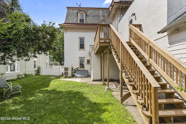 back of house featuring a patio area and a lawn